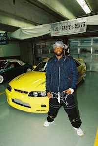 a man standing next to a toyota sports car